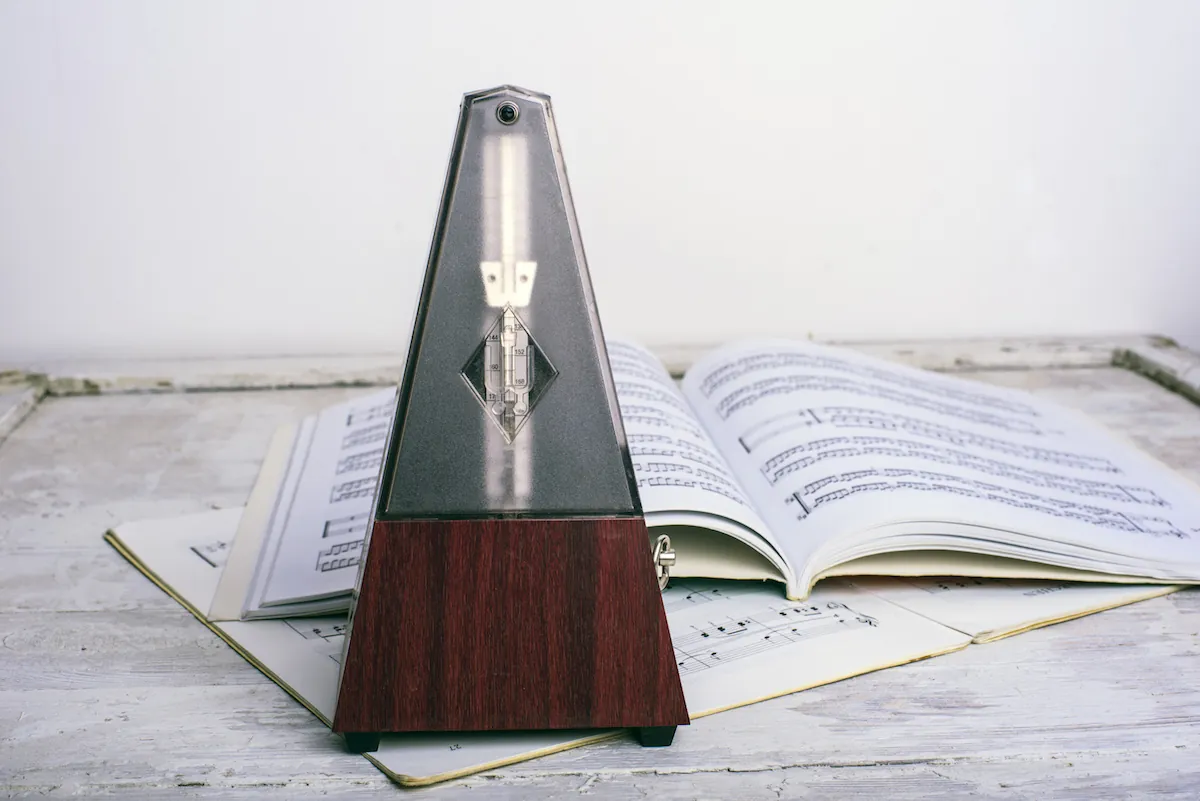 A metronome standing in front of open sheet music